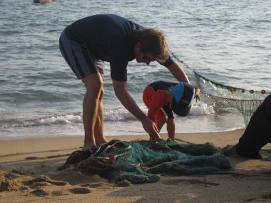 Helping the fishermen empty their nets at the front of the house