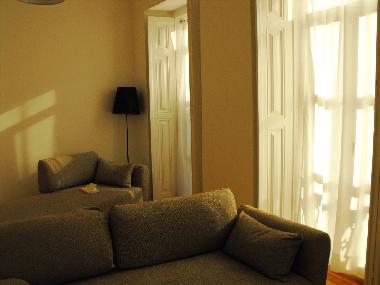 Living room with chaise longue and doors opening to the balcony