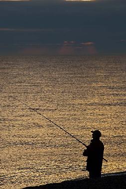 Sea fishing at dawn on Cley beach.