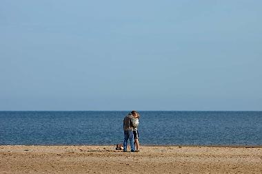 Young couple kissing on Holkham beach.