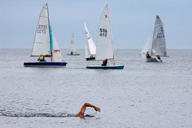 Swimmer and yacht race off Wells point.