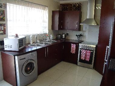 Open plan kitchen includes gas stove, washing machine, dish-washer, microwave, refrigerator