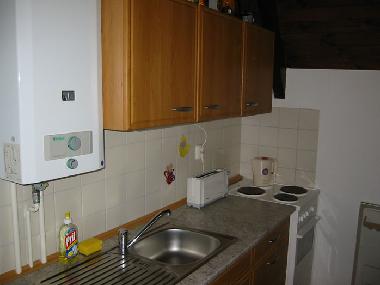 Kitchen with electric oven and hob + fridge freezer.
