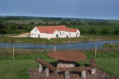Greetham Retreat viewed from seating area in grounds across the wildlife pond