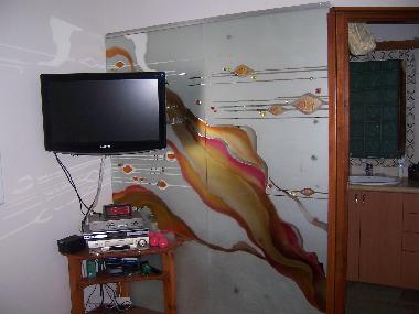TV in bedroom with entrance to the en-suite bathroom