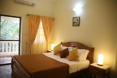 Airconditioned bedroom with attached balcony and attached European style toilet/bathroom with shower