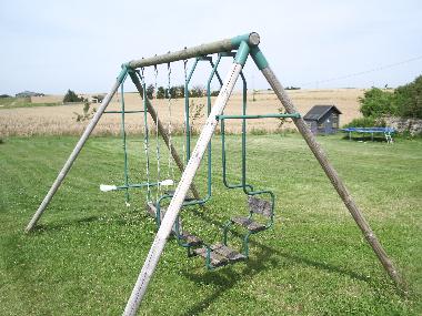 Large garden for children to rund around with a wendy house, trampoline & swings