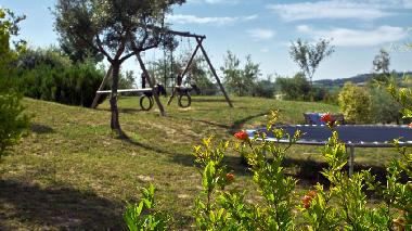 Childrens play area with triple swing and trampoline