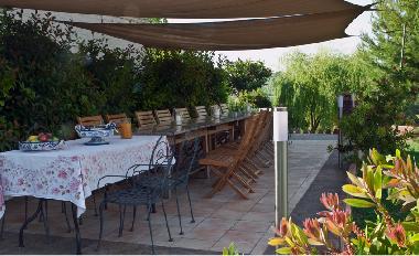 West patio area seating up to 25 guests with a barbecue