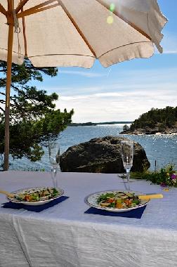 Patio with ocean in front and house in the back.