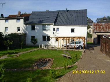 You will stay in the right house. Next to the place where the car is parking on the photo there is a