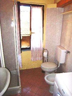 Main bathroom with shower, basin, toilet, bidet, and washing machine - conveniently located near the
