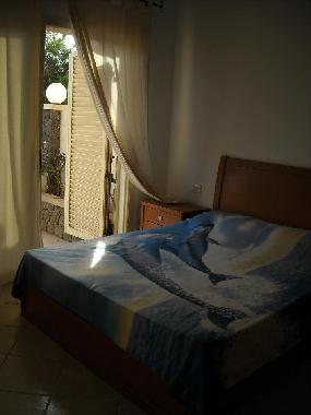 Bedroom with double bed and sliding door to the terrace.