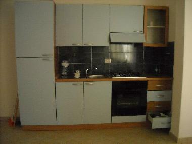 A kitchen with refrigerator and oven.