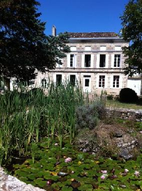The Manoir in summer with Lillies and reeds on the pond. 