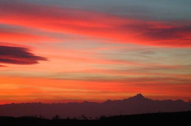 Sun set observed from the terrace of the holiday apartment. View to the Alps