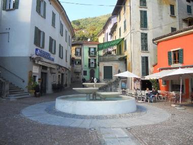 little square with fountain and restaurant and shops