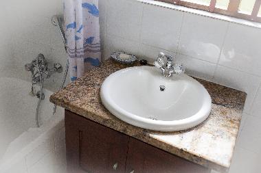 Bathroom has bath with shower