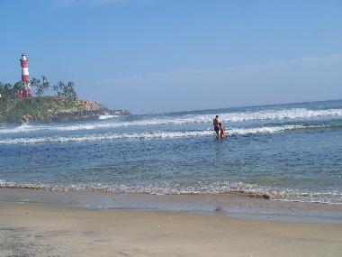 sun,sea  and sands .....at the background kovalam light house