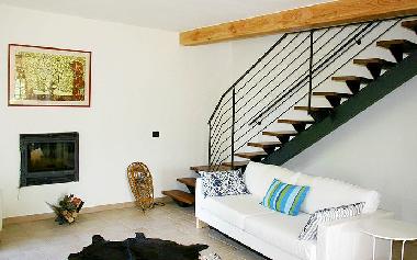The living room with fireplace,folding sofa and the stairs to the first floor