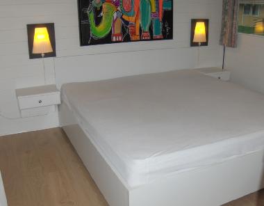 Bedroom with a double bed. Wood floor like other the bedroom