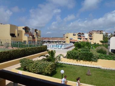 View from balcony to pool, tennis court and hills in the distance