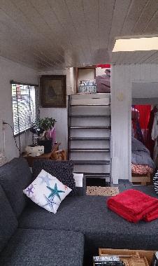 The living room with a corner bank and chair and TV