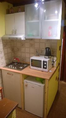 small kitchen with fridge, dishes, glass, coffee machine