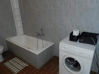 master bathroom with bathtub and washing machine 