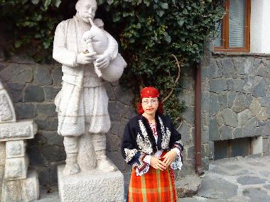 Shiroka Laka-The Statue of the Rhodopi Bagpiper at the Mayor's office with a local teacher in her gr
